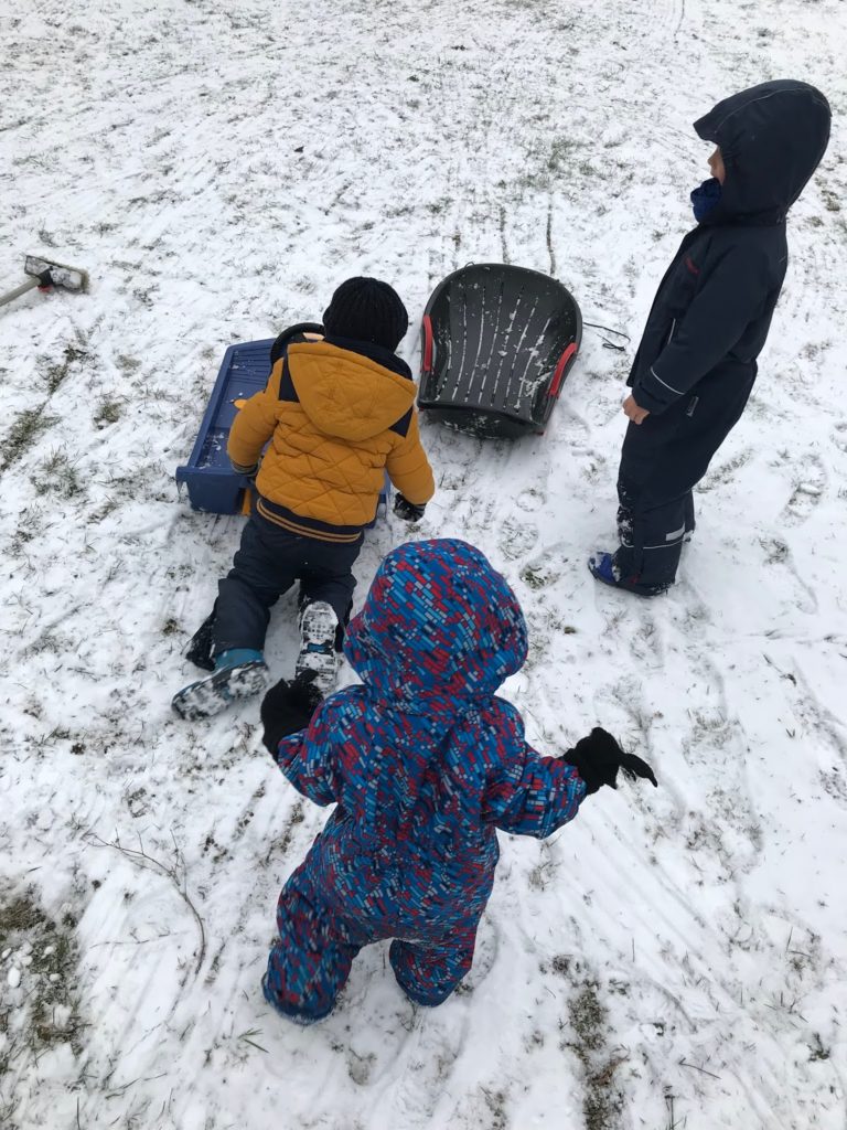 Schnee Schlittenfahren Winterkinder Winter Aktivitaeten vor der Haustuer